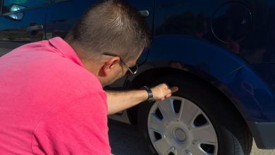 a man checking its vehicle's tire