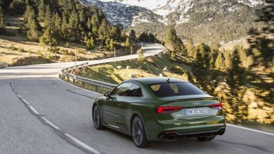 green audi traveling on a road